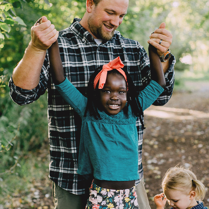 A father holding up his daughter by the hands