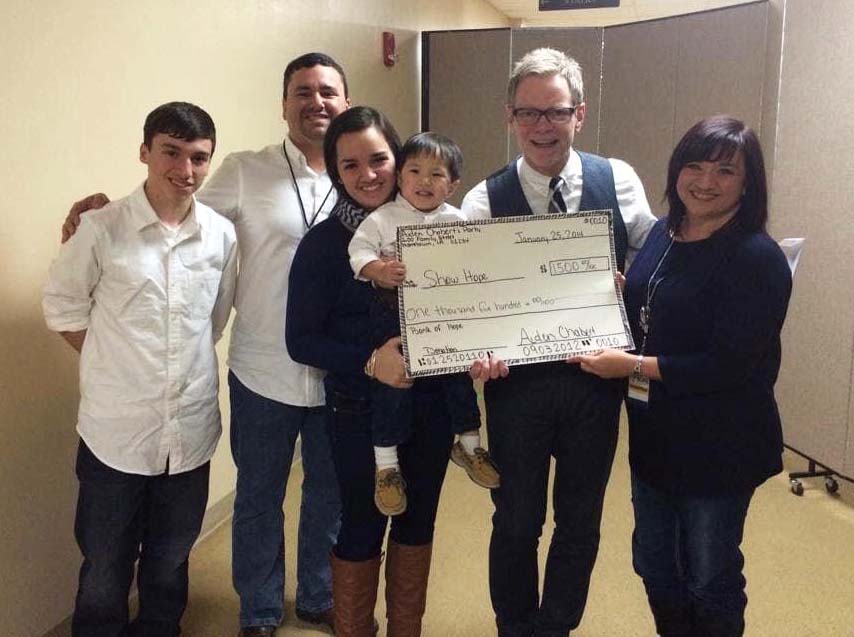 An image of Steven Curtis Chapman posing with the Chabert family and holding a check as a donation to Show Hope