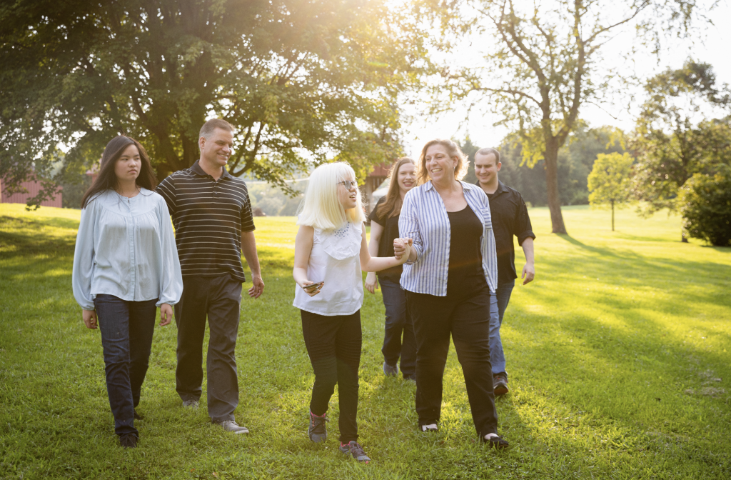 Helping Cate SEE | An image of Cate Wiley, her parents, Peggy and Bruce Wiley, and her three siblings walking through the park 