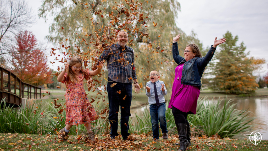Laurie Hart and her family throwing leaves in the air