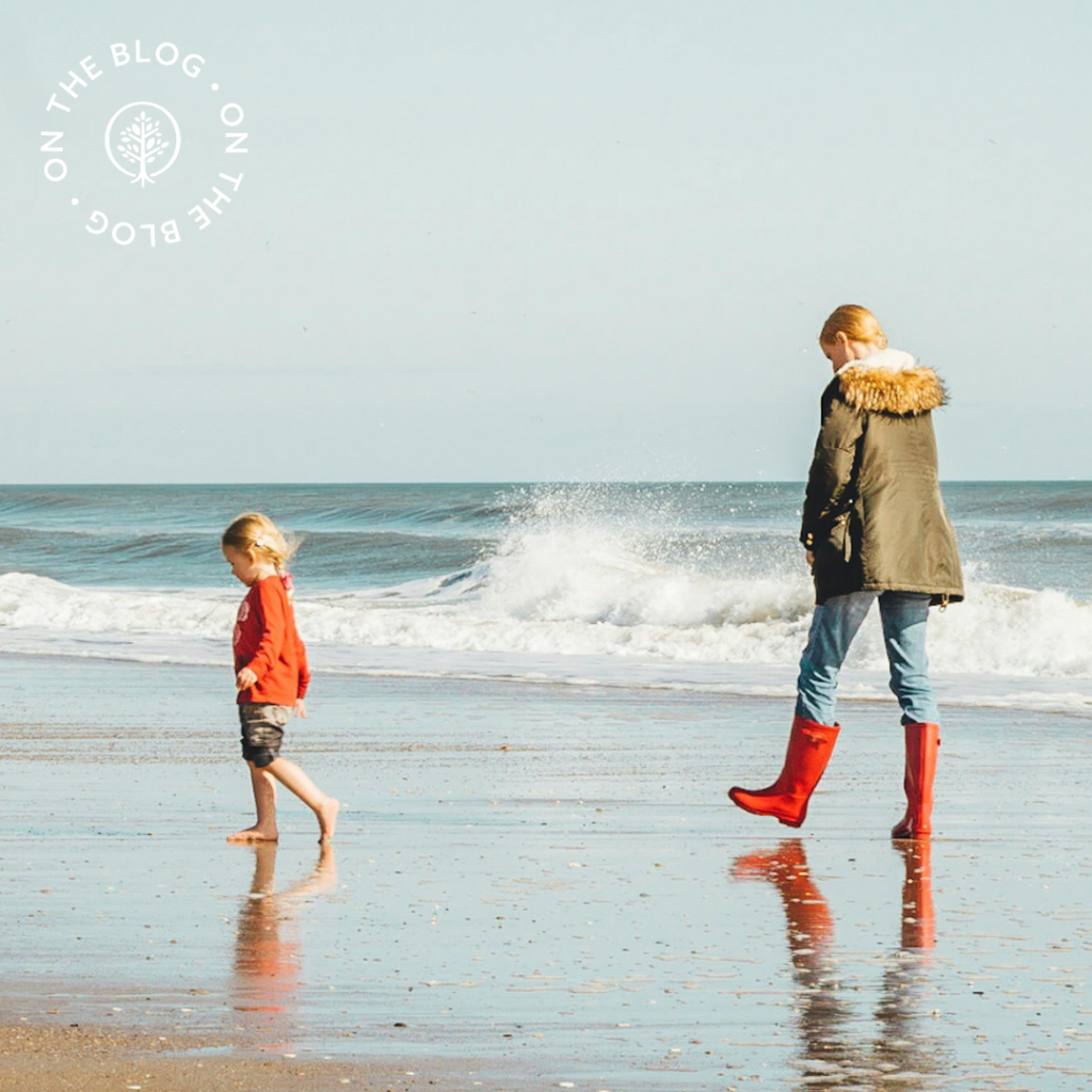 Woman and child walking on a beach