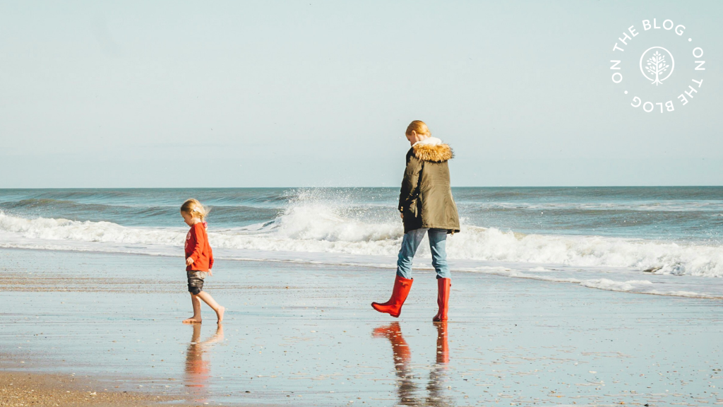 Woman and child walking on a beach